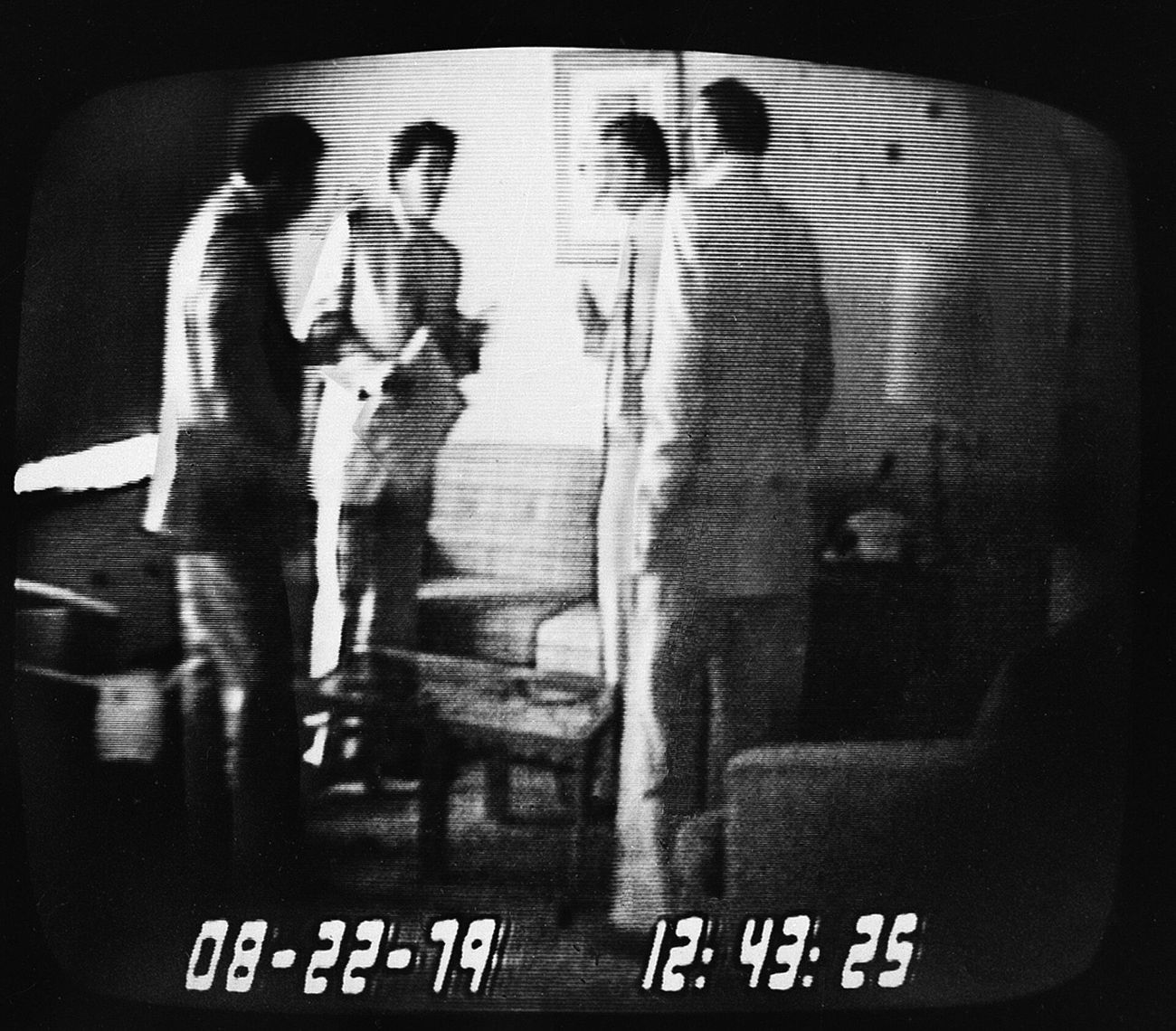 An FBI hidden-camera frame stamped 22 August 1979, 12:43: undercover agent Anthony Amoroso, Representative Michael “Ozzie” Myers holding an envelope, Camden mayor Angelo Errichetti and informant Mel Weinberg, from left. The FBI’s caption identifies the four.