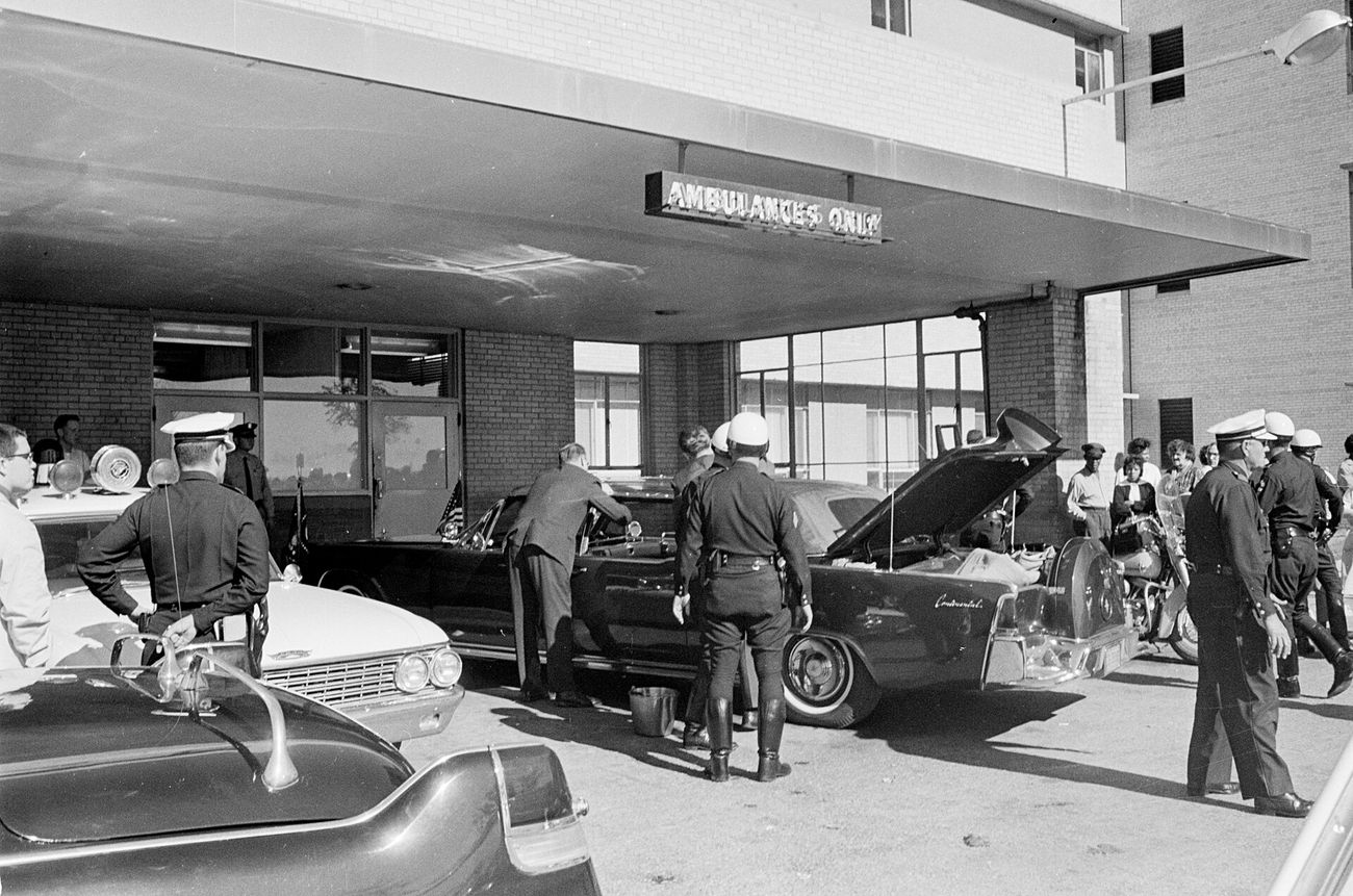 Police and agents gather around the limousine outside Parkland Hospital, 22 November 1963.
