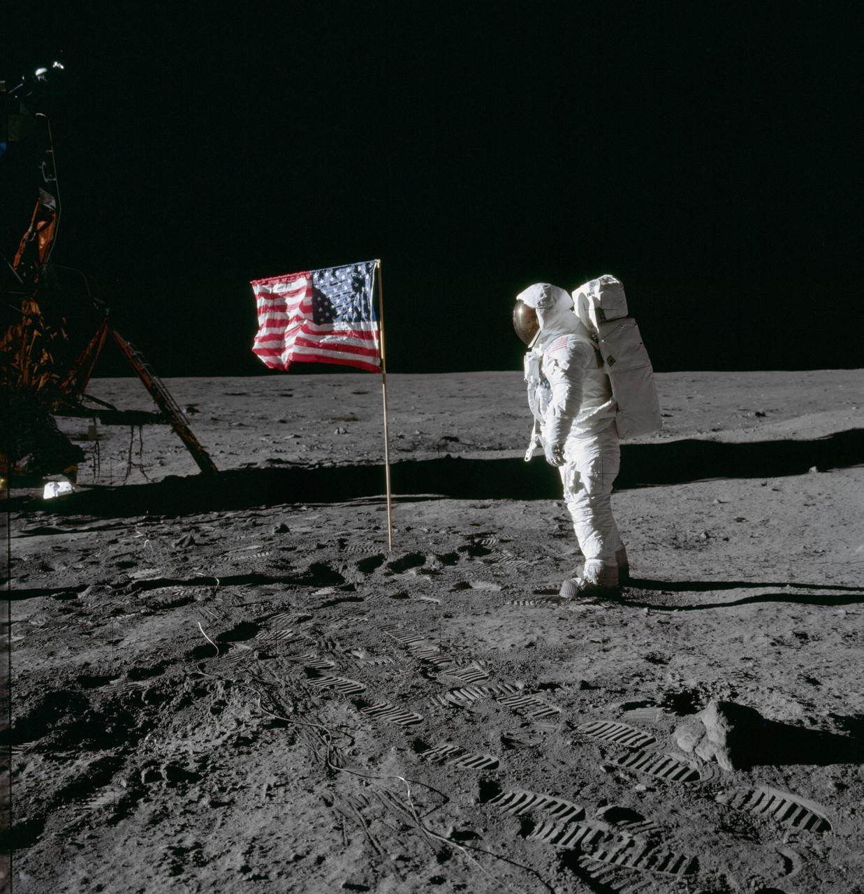Topic photograph: Astronaut Edwin E. Aldrin Jr., lunar module pilot of the first lunar landing mission, poses for a photograph beside the deployed United States flag during an Apollo 11 extravehicular activity (EVA) on the lunar surface. The Lunar Module (LM) is on the left, and the footprints of the astronauts are clearly visible in the soil of the moon. Astronaut Neil A. Armstrong, commander, took this picture with a 70mm Hasselblad lunar surface camera. While astronauts Armstrong and Aldrin descended in the LM, the "Eagle", to explore the Sea of Tranquility region of the moon, astronaut Michael Collins, command module pilot, remained with the Command and Service Modules (CSM) "Columbia" in lunar orbit. Photo credit: NASA