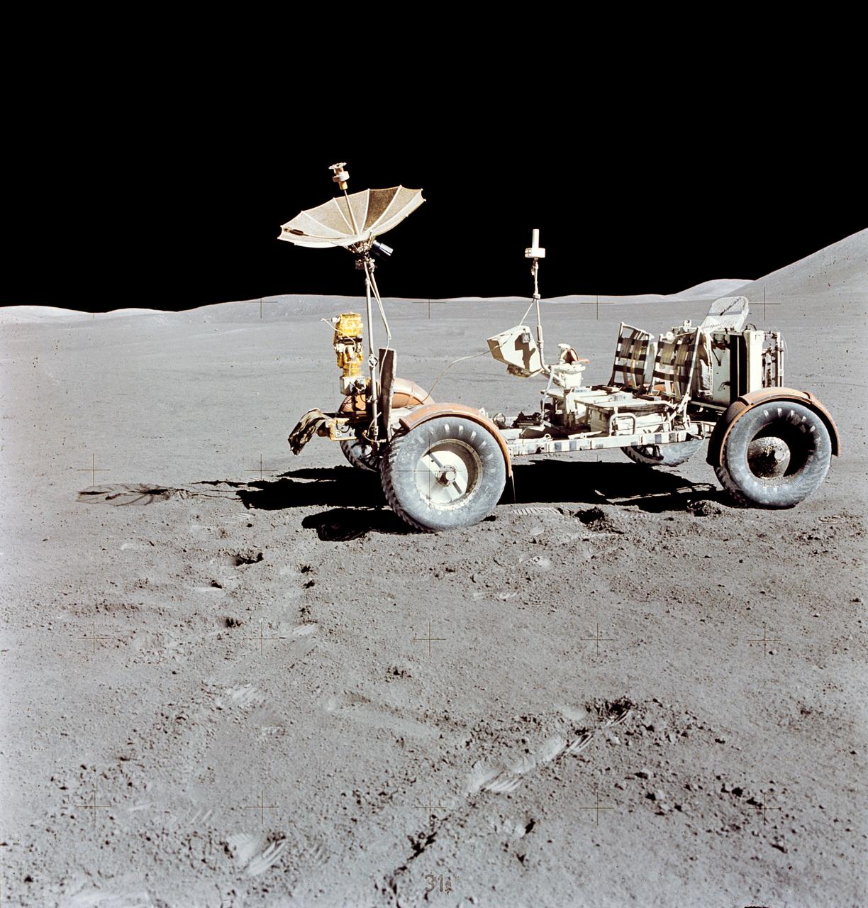 The Lunar Roving Vehicle (LRV) is photographed alone against the desolate lunar background during the third Apollo 15 lunar surface extravehicular activity (EVA) at the Hadley-Apennine landing site. This view is looking north. The west edge of Mount Hadley is at the upper right edge of the picture. Mount Hadley rises approximately 4,500 meters (about 4,765 feet) above the plain. The most distant lunar feature visible is approximately 25 kilometers (about 15.5 statute miles) away. While astronauts David R. Scott, commander; and James B. Irwin, lunar module pilot, descended in the Lunar Module (LM) "Falcon" to explore the moon, astronaut Alfred M. Worden, command module pilot, remained with the Command and Service Modules (CSM) in lunar orbit.