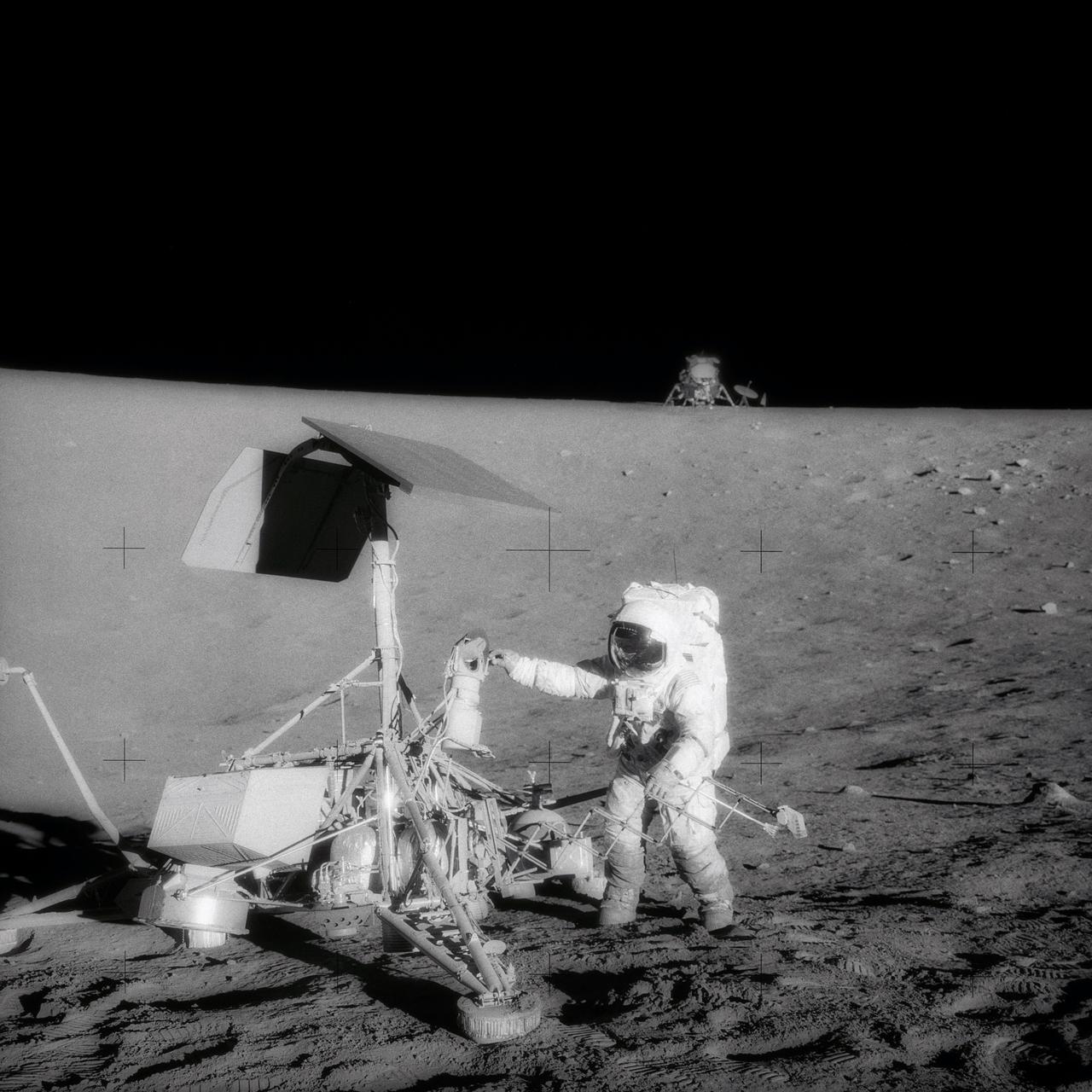 Topic photograph: This unusual photograph, taken during the second Apollo 12 extravehicular activity (EVA), shows two U.S. spacecraft on the surface of the moon. The Apollo 12 Lunar Module (LM) is in the background. The unmanned Surveyor 3 spacecraft is in the foreground. The Apollo 12 LM, with astronauts Charles Conrad Jr. and Alan L. Bean aboard, landed about 600 feet from Surveyor 3 in the Ocean of Storms. The television camera and several other pieces were taken from Surveyor 3 and brought back to Earth for scientific examination. Here, Conrad examines the Surveyor's TV camera prior to detaching it. Astronaut Richard F. Gordon Jr. remained with the Apollo 12 Command and Service Modules (CSM) in lunar orbit while Conrad and Bean descended in the LM to explore the moon. Surveyor 3 soft-landed on the moon on April 19, 1967.