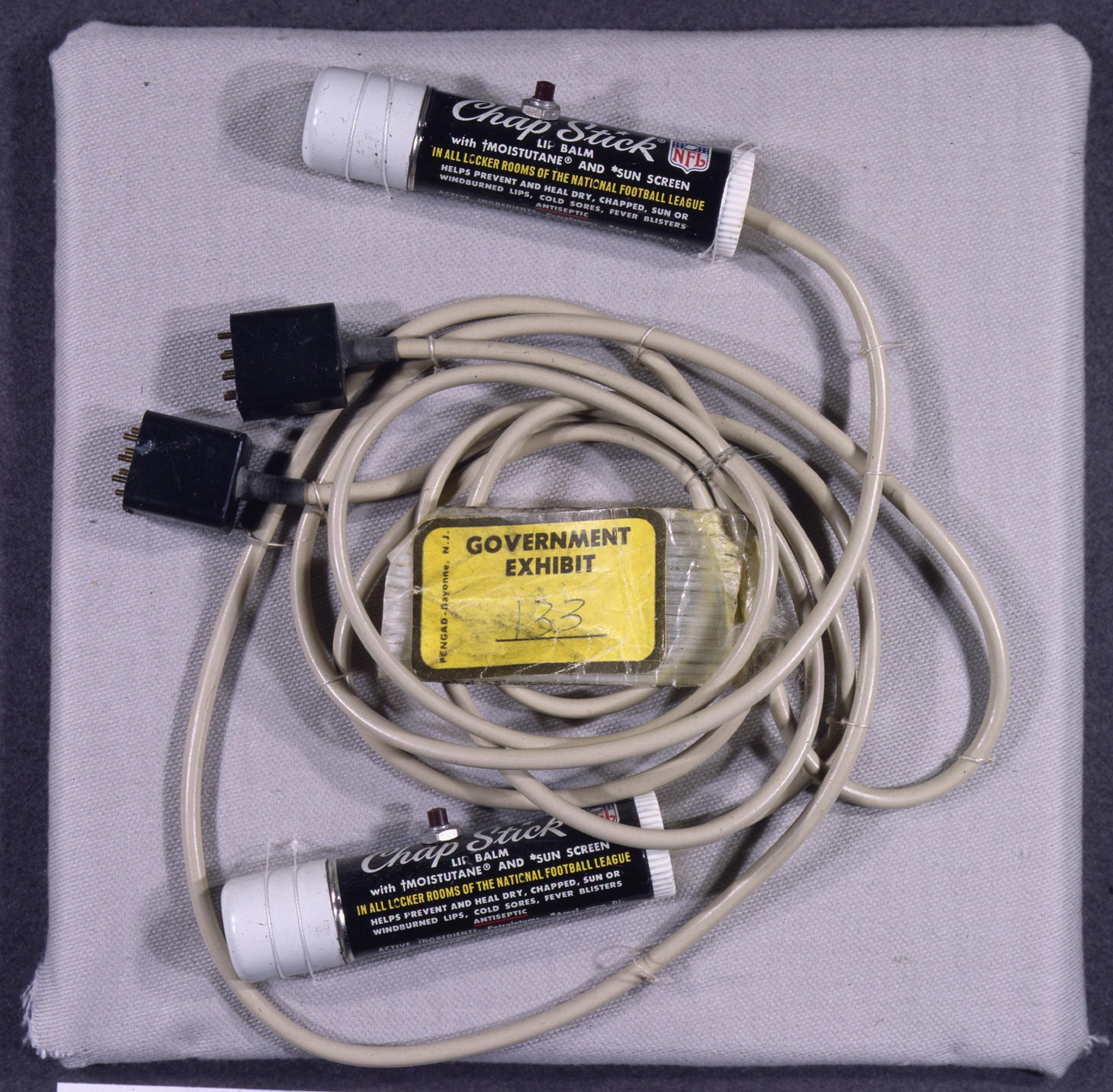 Government Exhibit 133: microphones concealed in ChapStick tubes, recovered from Howard Hunt’s White House office safe. Archival exhibit photograph; not a photograph taken inside the DNC during the burglary.