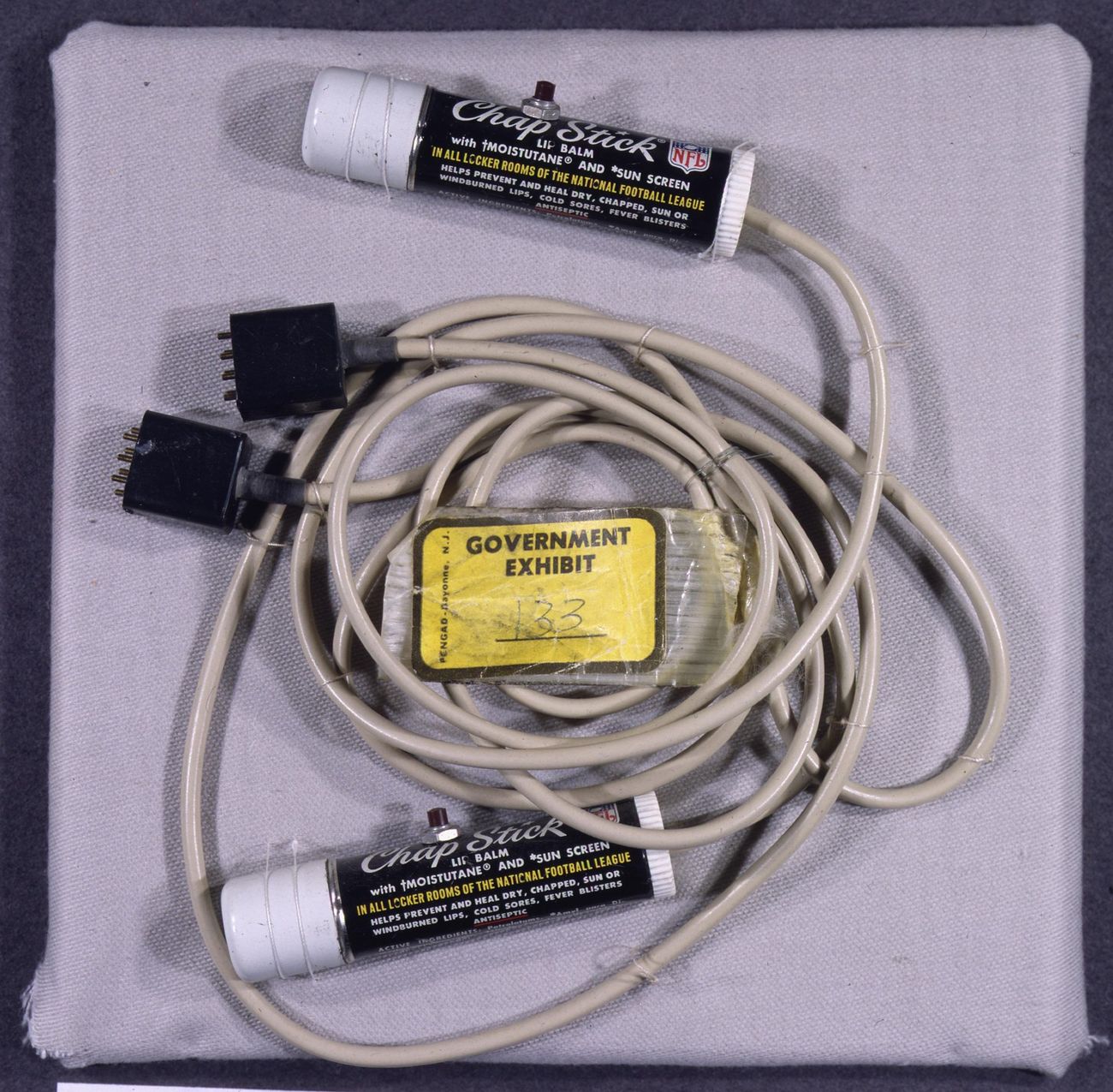 Government Exhibit 133: microphones concealed in ChapStick tubes, recovered from Howard Hunt’s White House office safe. Archival exhibit photograph; not a photograph taken inside the DNC during the burglary.