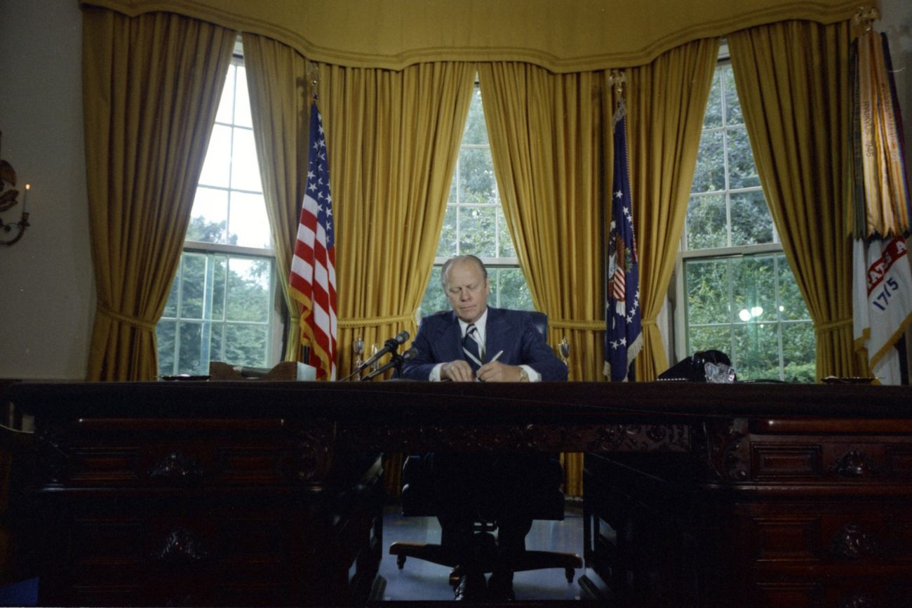 President Gerald Ford signs the Nixon pardon in the Oval Office, September 8, 1974.